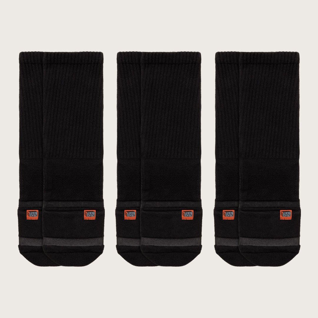 Three pairs of black Crease Beast Crew Pocket Socks, each with an orange Crease Beast label on the ankle.