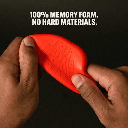 Hands squeezing a red Crease Beast Mini memory foam crease protector, showing its flexibility.